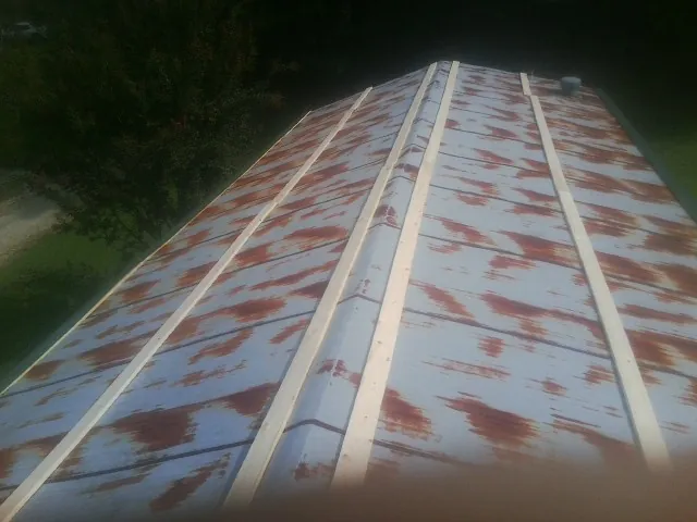 Rusted metal roof panels with new wood purlins before replacement — Storm Damage Roof Repair in Wilber by Roofing Brothers