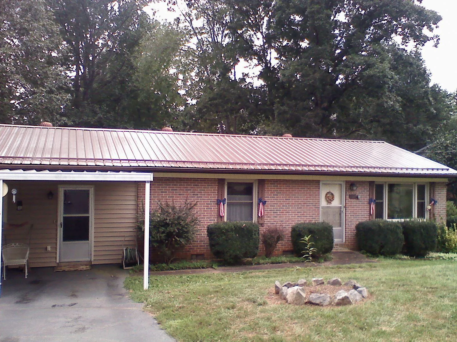 Bronze metal roof and carport on a brick ranch home — Roof Repair work by our crew in Wilber